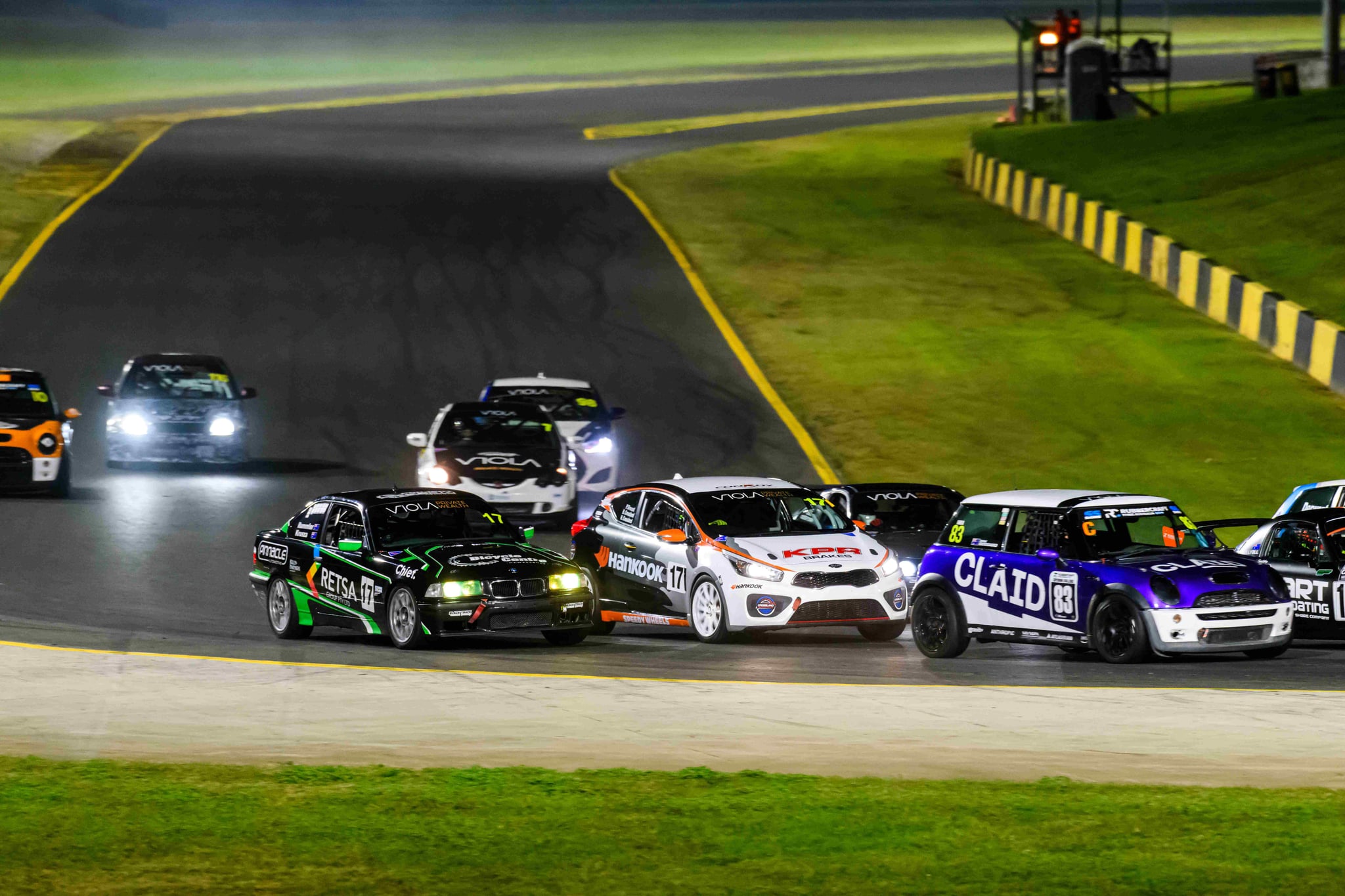 Project E36 #17 leading a tightly bunched pack into a corner under lights at the 2026 Sydney 300
